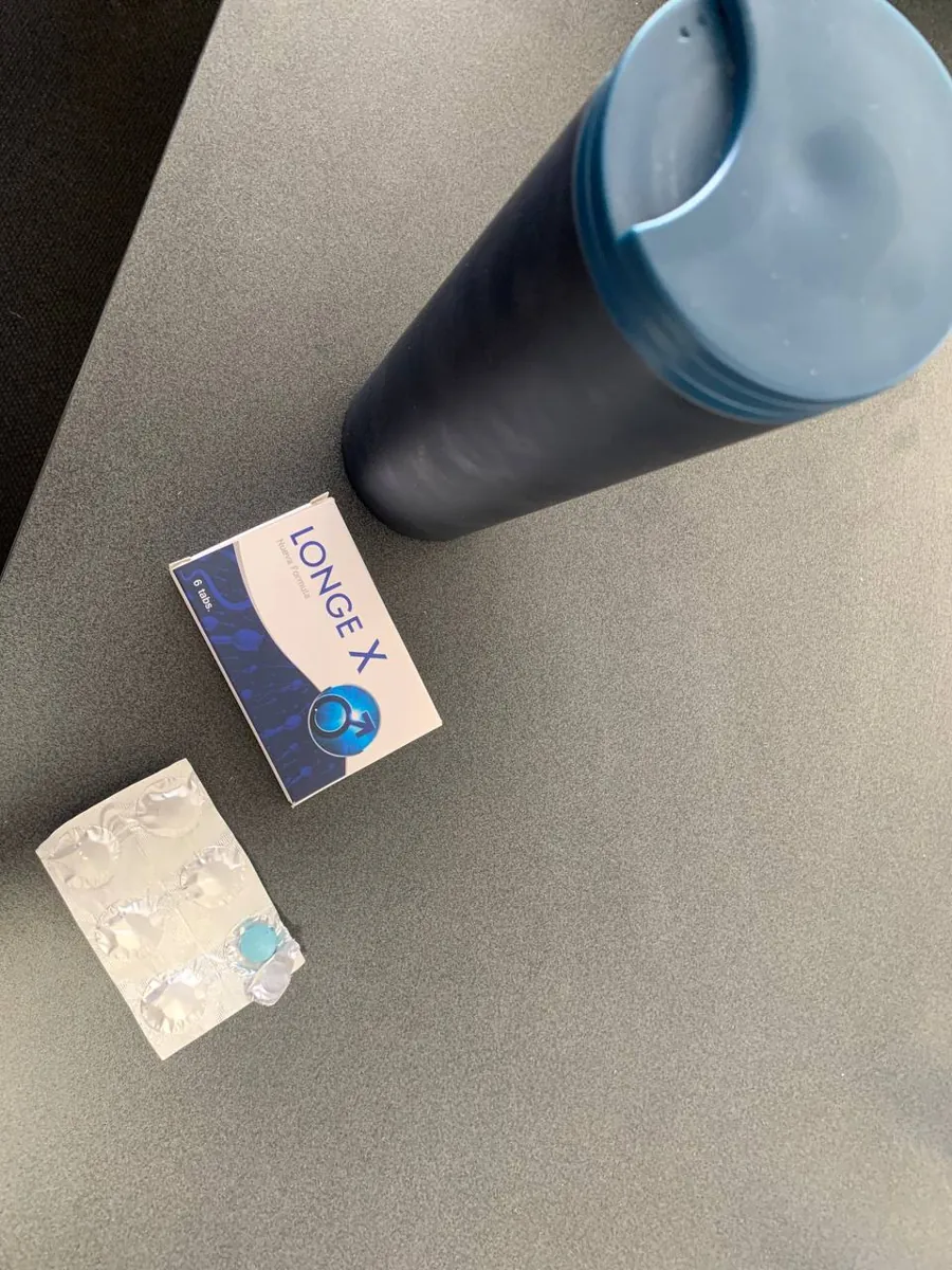 Caja de Longe X con blíster y tableta azul junto a una botella de agua deportiva