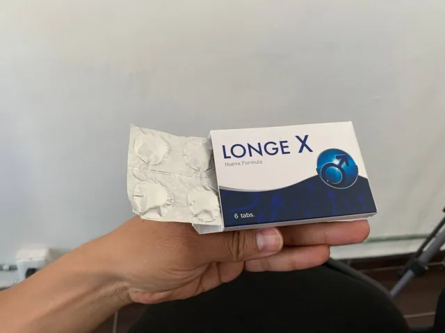 Mano sosteniendo la caja abierta de Longe X con su blíster